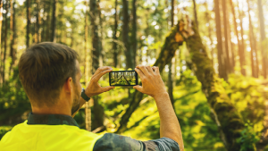 Mann fotografiert Sturmschäden mit dem Handy